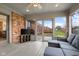Relaxing sunroom featuring brick accent wall, ceiling fan, and comfortable seating overlooking the backyard at 2054 Partridge Dr, Franklin, IN 46131