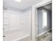 New bathroom has tiled shower and bathtub in clean bright white at 209 Pennsylvania St, Shirley, IN 47384