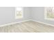 Bright, airy bedroom featuring wood floors and natural light from two windows at 209 Pennsylvania St, Shirley, IN 47384