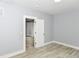 Bright bedroom with light-gray walls and wood-look floors with an open doorway at 209 Pennsylvania St, Shirley, IN 47384
