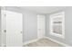 Bright bedroom with light-gray walls, wood-look floors, one window, and a door at 209 Pennsylvania St, Shirley, IN 47384