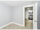 Bright bedroom with light-gray walls, wood-look floors, and an open doorway to the kitchen at 209 Pennsylvania St, Shirley, IN 47384