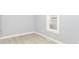 Bright bedroom with light-gray walls and wood-look floors featuring a window at 209 Pennsylvania St, Shirley, IN 47384