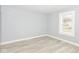 Bright bedroom with light-gray walls and wood-look floors with a view out the window at 209 Pennsylvania St, Shirley, IN 47384
