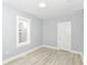 Bright bedroom with light-gray walls and wood-look floors and one window at 209 Pennsylvania St, Shirley, IN 47384