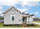 Charming gray home featuring a covered porch and well-maintained landscaping at 209 Pennsylvania St, Shirley, IN 47384