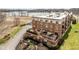 Aerial view of a condominium building with a rooftop terrace, manicured landscaping, and nearby lake access at 20971 Shoreline Ct # Apt 212, Noblesville, IN 46062
