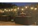 The backyard patio area has ample storage with patio boxes and is enhanced by a decorative trellis with festive string lights at 20971 Shoreline Ct # Apt 212, Noblesville, IN 46062