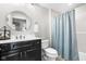 Cozy bathroom features a vanity with round mirror and a shower with a blue curtain, and toilet at 20971 Shoreline Ct # Apt 212, Noblesville, IN 46062