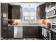 Close-up of a kitchen sink with dark cabinets and decorative backsplash tiles at 20971 Shoreline Ct # Apt 212, Noblesville, IN 46062