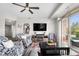 Bright living room featuring a ceiling fan, TV, and access to a balcony with outdoor seating at 20971 Shoreline Ct # Apt 212, Noblesville, IN 46062