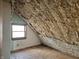 A textured attic featuring a window and hardwood floors at 21977 Craig Ave, Noblesville, IN 46060