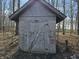 A well-kept, gray outbuilding with a single door in a wooded location at 21977 Craig Ave, Noblesville, IN 46060