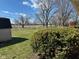 View of the spacious back yard, partial fence line, mature trees and a storage shed on a partly cloudy day at 2309 Dover St, Anderson, IN 46013