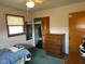 Cozy bedroom featuring a comfortable bed, a classic dresser, and a built-in closet with louvered doors at 2309 Dover St, Anderson, IN 46013