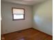 Empty bedroom with natural light, hardwood floors, and a window with white blinds at 2309 Dover St, Anderson, IN 46013