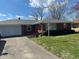 Charming brick home with a well-manicured lawn, concrete driveway, and an attached one-car garage at 2309 Dover St, Anderson, IN 46013