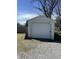 Single car garage with white siding and metal roof located on a gravel parking pad at 238 S Main St, Wilkinson, IN 46186
