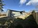 View of the fenced backyard and the side of this charming home with green siding and lush lawn at 240 E Caven E St, Indianapolis, IN 46225