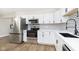 Stunning modern kitchen featuring stainless appliances, elegant white cabinetry, and beautiful back splash at 240 E Caven E St, Indianapolis, IN 46225