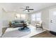 Bright living room featuring neutral walls, contemporary furniture, a modern ceiling fan, and stylish rug at 240 E Caven E St, Indianapolis, IN 46225