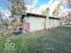 Exterior shot of the back of the house with overgrown grass and a chimney at 2505 E 17Th St, Indianapolis, IN 46218