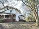 Side view of a two-story house with white siding and a red brick foundation, visible in the fall season at 2505 E 17Th St, Indianapolis, IN 46218