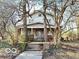 Two story home with trees framing the entrance stairs, and a covered front porch at 2505 E 17Th St, Indianapolis, IN 46218