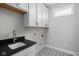 Functional laundry room featuring sleek countertops, white cabinets, and designer tile floors at 2786 Kipling Dr, Carmel, IN 46033