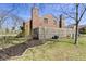 View of a brick townhouse with a grassy backyard and a wooden privacy fence at 310 E St Clair St, Indianapolis, IN 46202