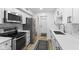 A modern kitchen featuring white cabinets, stainless steel appliances, and geometric backsplash at 310 E St Clair St, Indianapolis, IN 46202