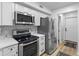 A bright, modern kitchen with stainless steel appliances, white cabinets, and geometric backsplash at 310 E St Clair St, Indianapolis, IN 46202