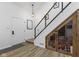 A staircase in a home with wood floors, a wine rack, and a glass-paneled wine storage area underneath at 310 E St Clair St, Indianapolis, IN 46202