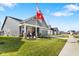 Charming gray home with a well manicured lawn, welcoming front porch, and flags on a sunny day at 3121 Arkle Rd, Westfield, IN 46074