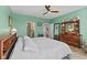 Bright main bedroom features ensuite bathroom access, ceiling fan, and decorative wood dresser with mirror at 3121 Arkle Rd, Westfield, IN 46074