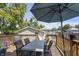 Back deck with table, seating, and an umbrella in a landscaped backyard at 3345 Ruckle St, Indianapolis, IN 46205
