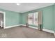 Bedroom featuring neutral carpet, light green walls, natural light from windows, and a clean, minimalist aesthetic at 3345 Ruckle St, Indianapolis, IN 46205