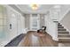 Bright foyer with hardwood floors, a white staircase, and a coat rack with seating at 3345 Ruckle St, Indianapolis, IN 46205