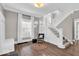 Cozy foyer with hardwood floors, a staircase, and a decorative chair next to a window at 3345 Ruckle St, Indianapolis, IN 46205