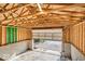 An unfinished garage with exposed wood beams, concrete floor, and an open garage door at 3345 Ruckle St, Indianapolis, IN 46205