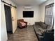 A modern living room with stylish flooring, comfortable seating, and a sliding barn door that adds character to the space at 3422 Hillside Ave, Indianapolis, IN 46218