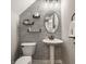 Stylish powder room with modern fixtures, decorative wallpaper, and elegant mirror at 3535 Buckner Dr, Westfield, IN 46074