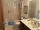Standard bathroom featuring a tub with shower curtain, vanity with countertop sink, and neutral-toned decor at 3760 Briar Hill Way, Columbus, IN 47203