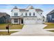Two-story home with white siding, a two-car garage, brick accents, and a well-manicured lawn at 4241 Risen Star Way, Bargersville, IN 46106