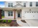 Covered front porch featuring brick columns, a blue front door with a wreath, and a walkway at 4241 Risen Star Way, Bargersville, IN 46106