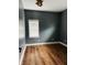 Bedroom with dark gray walls, a window letting in natural light, and light hardwood floors at , Indianapolis, IN 46201