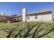 The backyard features a spacious deck and lawn with tree shadows in this charming single-Gathering home at 4655 Welton St, Greenwood, IN 46143