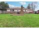 Backyard with large lawn, brick exterior, and a wooden deck at 4911 Carry Back Ln, Indianapolis, IN 46237