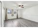 Spacious bedroom featuring gray vinyl flooring, ceiling fan, and natural light from windows at 4911 Carry Back Ln, Indianapolis, IN 46237