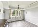 Bright dining area with large windows, updated light fixture, and gray vinyl floors at 4911 Carry Back Ln, Indianapolis, IN 46237